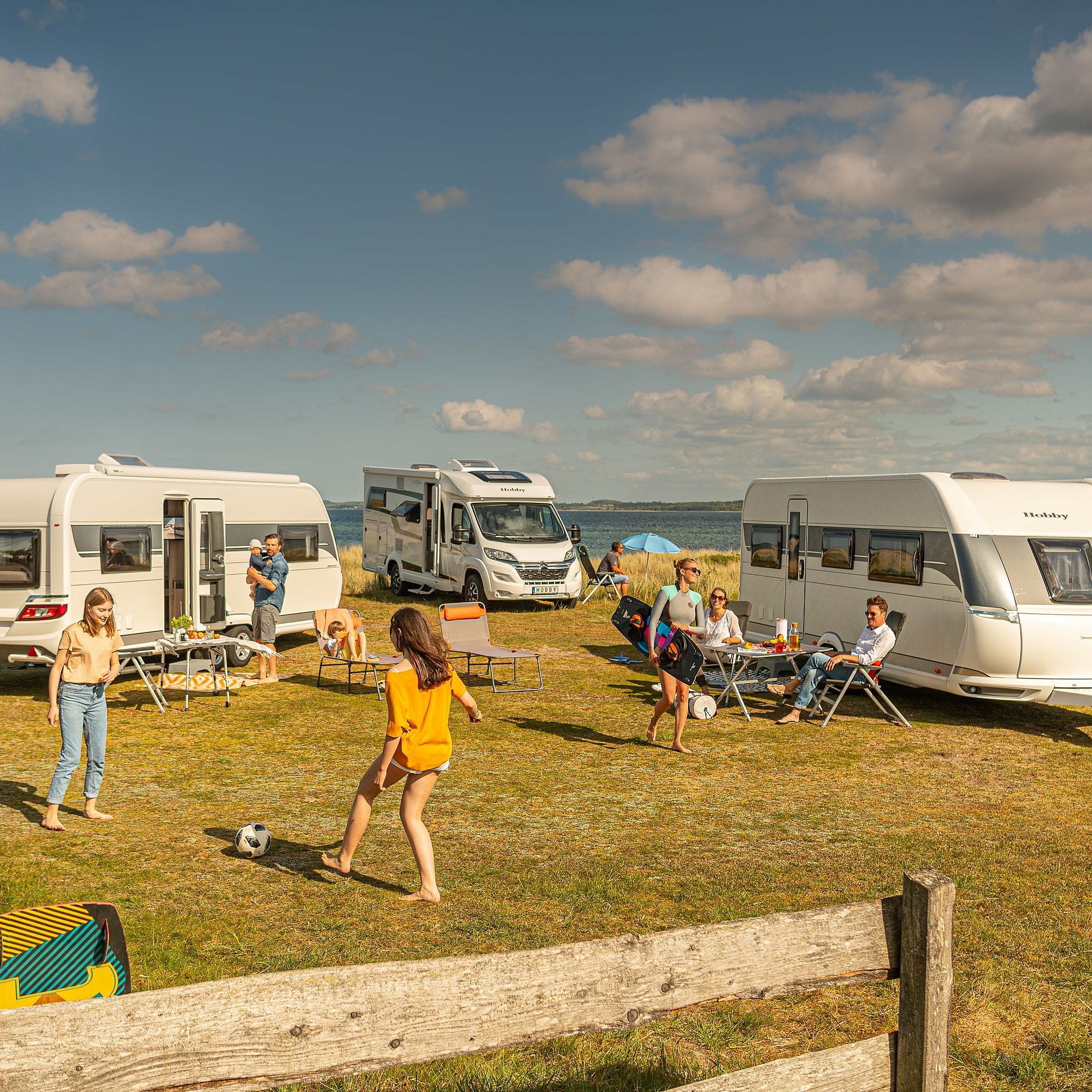 Mehrere Wohnwagen stehen auf einem Campingplatz.